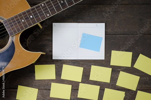 Fotomural Desk of song composer for a work songwriter with a guitar and notepad on wood table