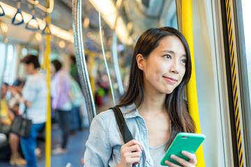 Canvas Print - Woman using mobile phone inside a train car