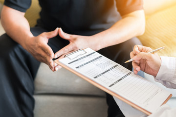 Wall Mural - Doctor consulting male patient, working on diagnostic examination on men's health disease or mental illness, and writing on prescription record information document in clinic or hospital office