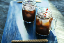 Mason Jars With Cold Brew Coffee On Wooden Tray