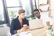 © LIGHTFIELD STUDIOS - portrait of multicultural focused businessmen working on laptop at workplace