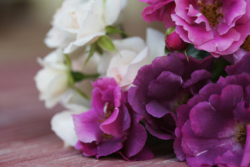 Wall Mural - Bouquet of pink and purple garden roses on a wooden background