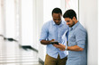 © seanlockephotography - Workspace: Coworkers Discussing Data On Tablet In Hallway