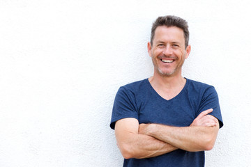 Close up laughing casual man standing with arms crossed