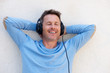 © mimagephotos - Close up happy man with headphones eyes closed in relaxation