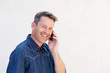 © mimagephotos - Close up happy older man talking on mobile phone