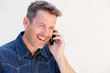 © mimagephotos - Close up older man laughing and talking on mobile phone