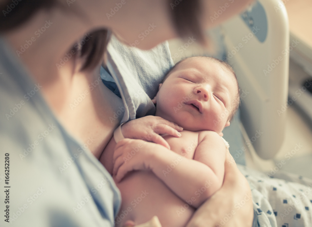 Parenting and new life concept. Mother holding newborn baby boy in her arms.  - obrazy, fototapety, plakaty 