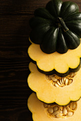 Sliced raw acorn squash on dark background