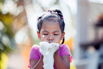 Wall Mural - Happy asian child girl having fun to bath and play with foam in outside