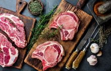 Raw Pork Cutlet Chop For Fry On Grill And Pan With Herbs, Garlic On Wooden Boards, Slate Gray Background