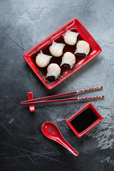 Wall Mural - Top view of steamed prawn hargows in soy sauce, vertical shot on a grey stone surface