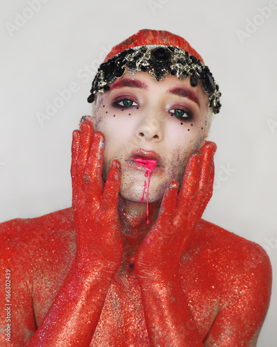 Man Model At The Red Art Make Up With Green Eyes Keeps Hand Near
