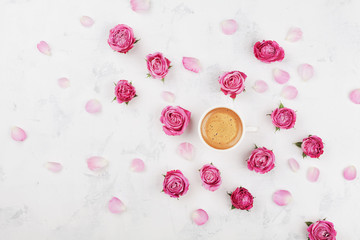 Wall Mural - Morning coffee cup, petals and beautiful pink rose flowers on white stone table top view in flat lay style. Cozy breakfast on Mother or Woman day.