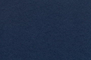 texture of old navy blue paper closeup. structure of a dense cardboard. the denim background.