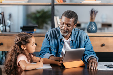 man using tablet with daughter