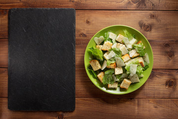 Canvas Print - caesar salad in plate at wood