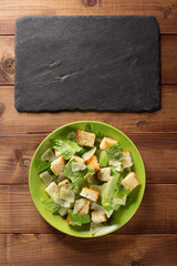 Canvas Print - caesar salad in plate at wood