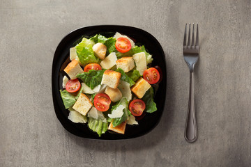 Canvas Print - caesar salad in plate at table