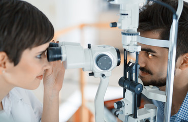 Poster - Woman doing eye test with optometrist in eye sight clinic