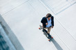 © michela ravasio/Stocksy - Young businessman going to work on a skateboard