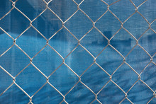 Chain-link Fence In Front Of Blue Plastic Tarp At Construction Site