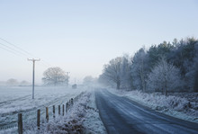 Icy Rural Road Through Mist.