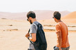 © AlejandroMCB photo & film/Stocksy - Two young men walking through the desert on adventure travel