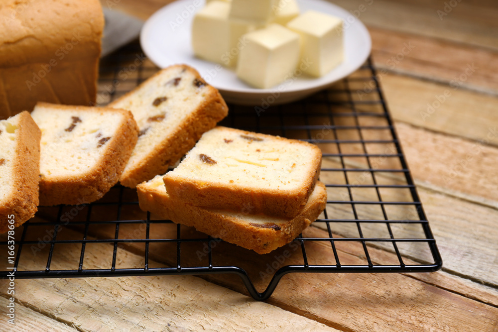 Cooling rack with delicious butter cake on wooden table