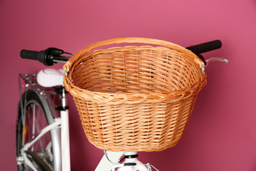 Wall Mural - Bicycle with empty wicker basket on color background