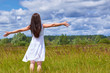 © Sviatoslav Kovtun - Girl in white dress standing in the field enjoying privacy. Bright blue clouds in the sky, the green grass with spikes