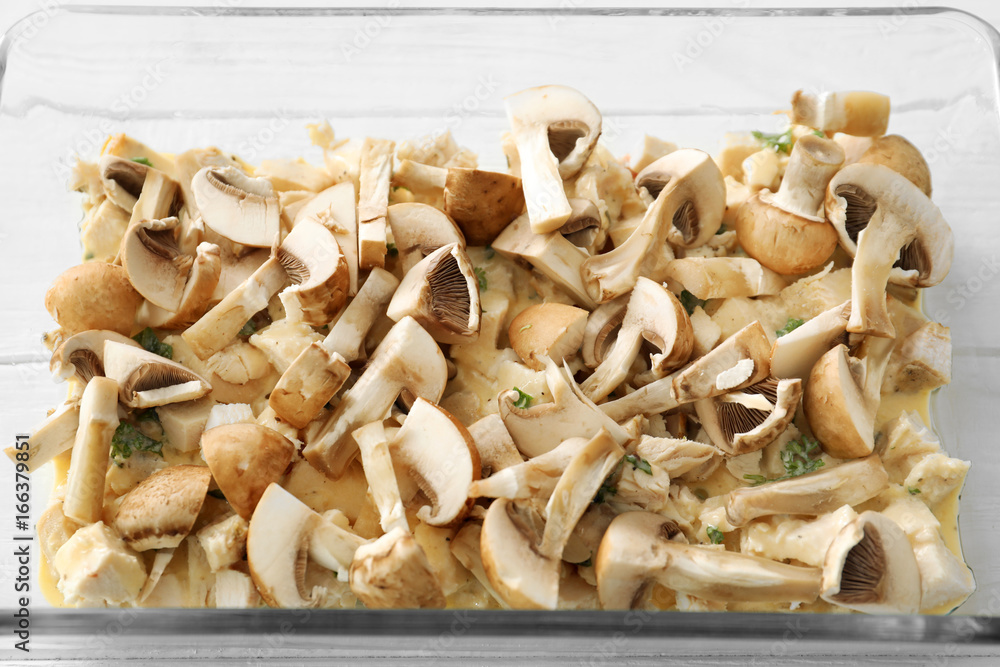 Baking tray with mushrooms and turkey meat on table, closeup