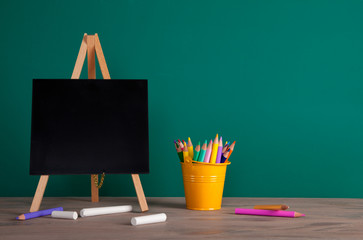 Back to school concept with school supplies. Colorful pencils and Blackboard with copy space