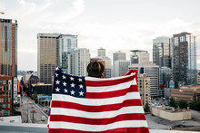 American flag over a cityscape.