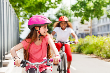 Wall Mural - Happy girls riding bikes during summer vacation