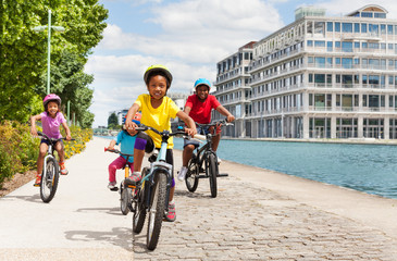 Wall Mural - African girl cycling with friends along a river