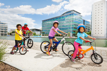 Wall Mural - African children enjoying cycling together in town