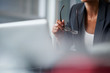 © Stocksy - business woman thinking while holding spectacles