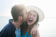 © Chelsea Victoria/Stocksy - A young couple laughing and kissing while on vacation