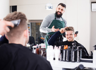 Happy man client discussing his future haircut