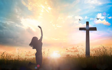 Happy Thanksgiving Day Concept: Silhouette Of Beautiful Woman Kneeling And Raised Hands On The Cross Autumn Sunrise Background