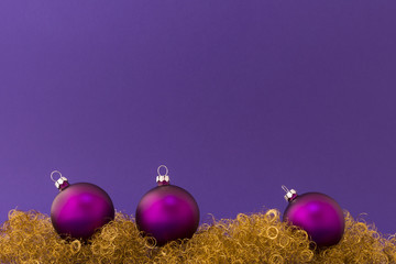 Wall Mural - Beautiful purple christmas balls with satin effect on gold glitter and purple background.