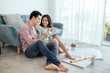 © makistock - Attractive young asian adult couple looking at house plans.