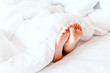 © Art_Photo - Young woman's bare feet on white blanket
