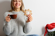 © Olha Afanasieva - Beautiful smiling young woman drinks cocoa with ginger Christmas cookies, looks at the camera