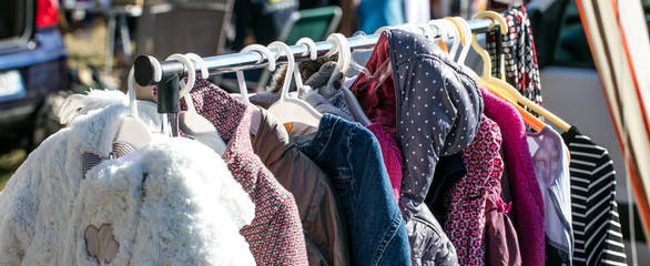 Wall Mural - rack of second hand winter baby jackets at flea market