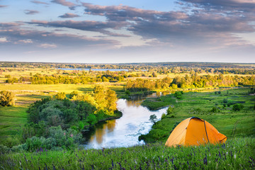 Wall Mural - Orange tent on the high bank of the river