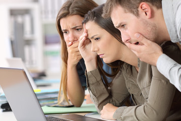 Canvas Print - Worried employees reading bad news on line