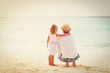 father and little daughter hug on beach