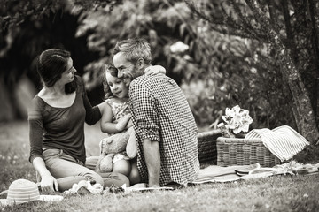 Poster - Cheerful family sitting on the grass during a picnic